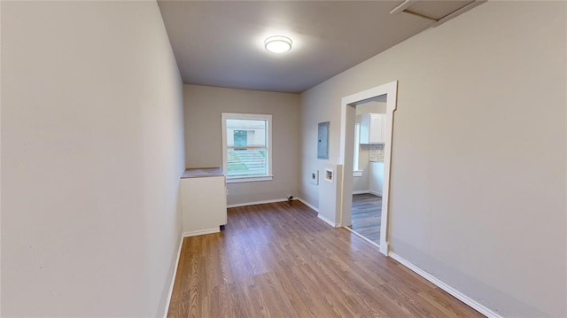 empty room featuring light wood-type flooring and electric panel