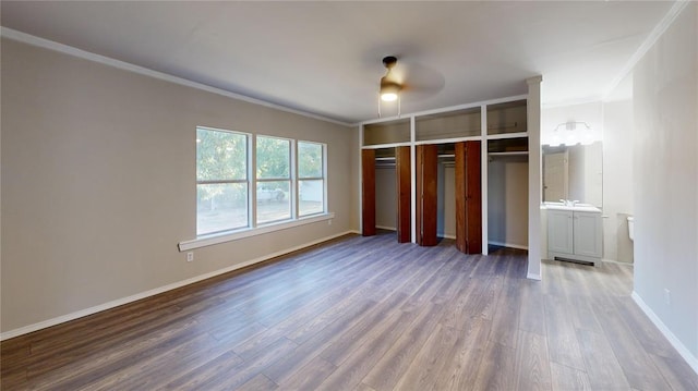 unfurnished bedroom with a closet, ceiling fan, crown molding, and wood-type flooring