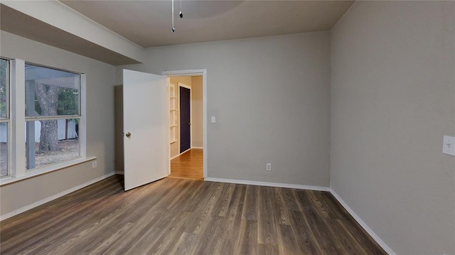 empty room featuring dark hardwood / wood-style floors and crown molding