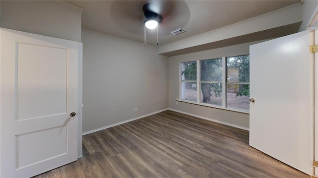 spare room featuring ceiling fan and dark wood-type flooring