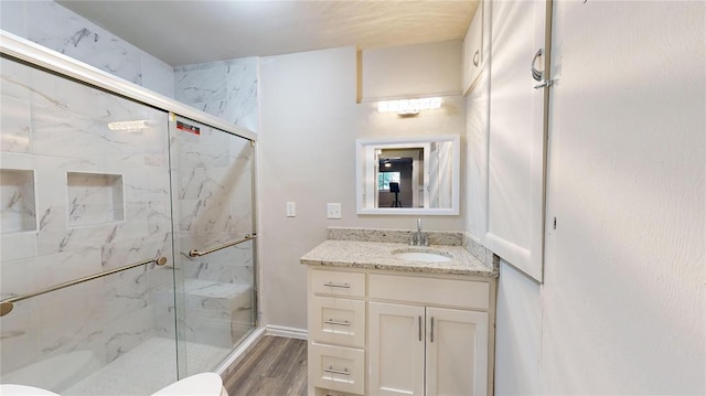 bathroom featuring walk in shower, toilet, vanity, and hardwood / wood-style flooring