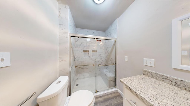 bathroom with toilet, vanity, an enclosed shower, and hardwood / wood-style flooring