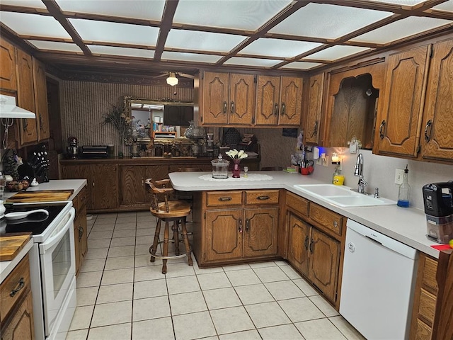 kitchen featuring ceiling fan, sink, extractor fan, white appliances, and a breakfast bar area