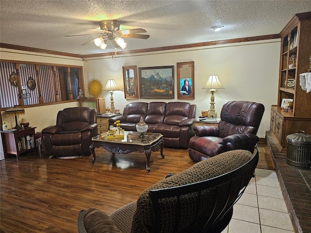 living room featuring crown molding, ceiling fan, light hardwood / wood-style floors, and a textured ceiling