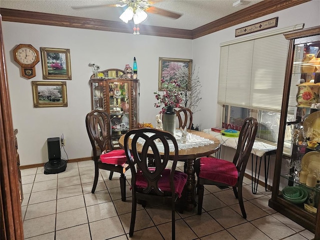 tiled dining area featuring ceiling fan, a textured ceiling, and ornamental molding