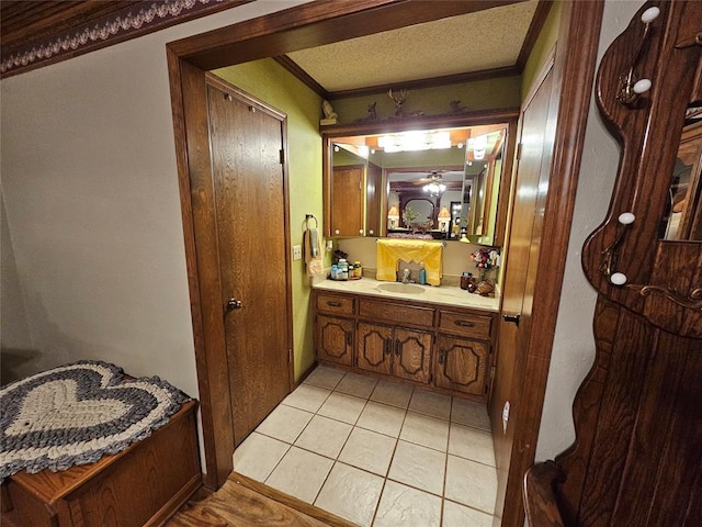 bathroom featuring vanity, tile patterned floors, crown molding, ceiling fan, and a textured ceiling