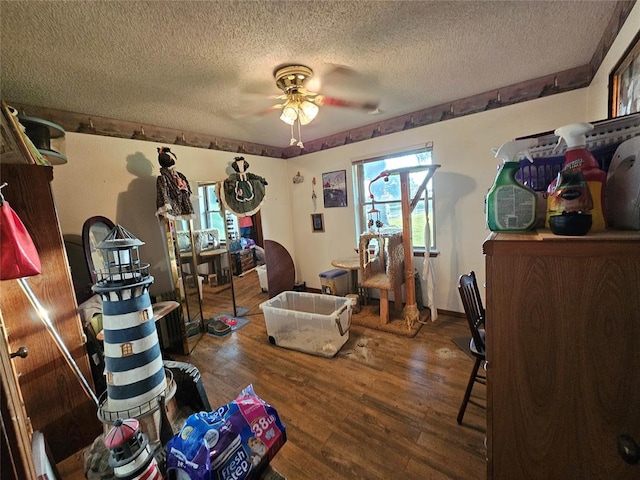 interior space with ceiling fan, a textured ceiling, and hardwood / wood-style flooring