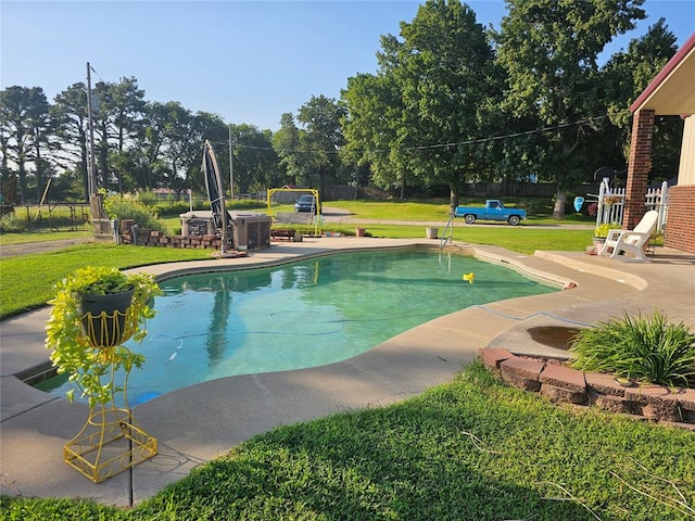 view of pool featuring a patio area and a yard