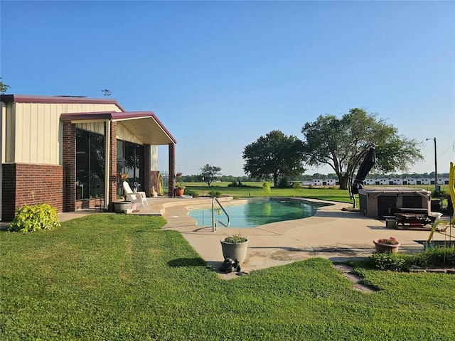 view of pool featuring a lawn and a patio area