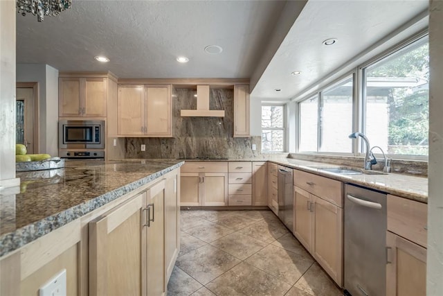 kitchen featuring light stone countertops, sink, stainless steel appliances, light brown cabinetry, and custom exhaust hood