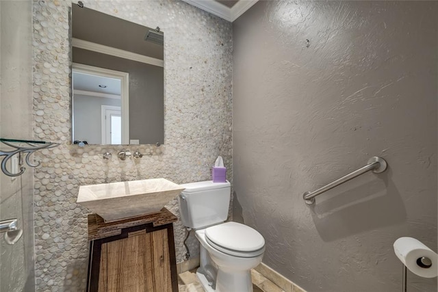 bathroom with sink, ornamental molding, and toilet