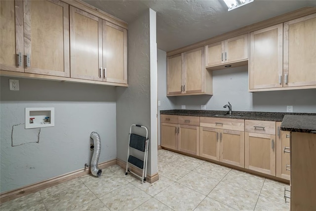 interior space with sink, dark stone countertops, light tile patterned floors, light brown cabinetry, and heating unit