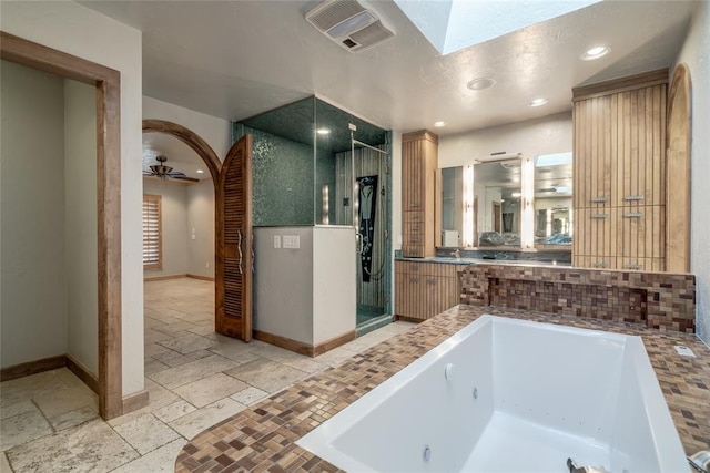 bathroom featuring ceiling fan and independent shower and bath