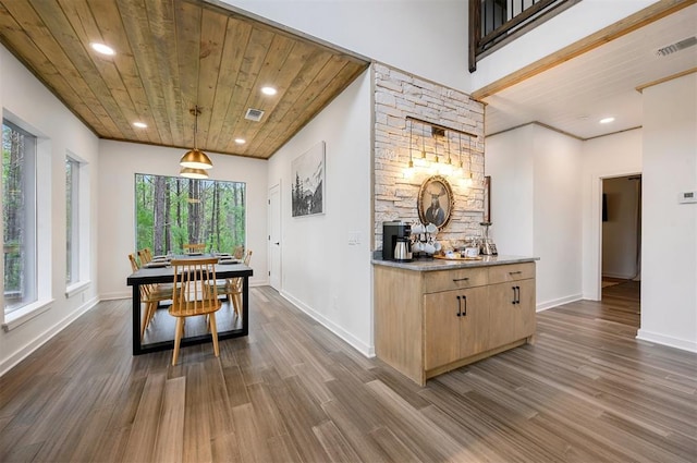 dining space featuring dark hardwood / wood-style flooring, plenty of natural light, and wood ceiling