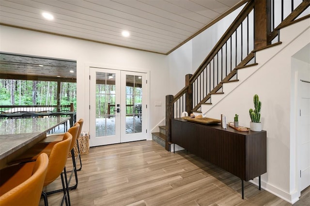 foyer featuring wooden ceiling, french doors, a healthy amount of sunlight, and light hardwood / wood-style flooring