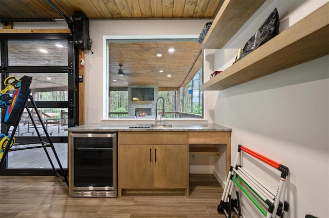 kitchen featuring wooden ceiling, light hardwood / wood-style flooring, beverage cooler, and plenty of natural light