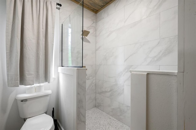 bathroom with toilet and a tile shower