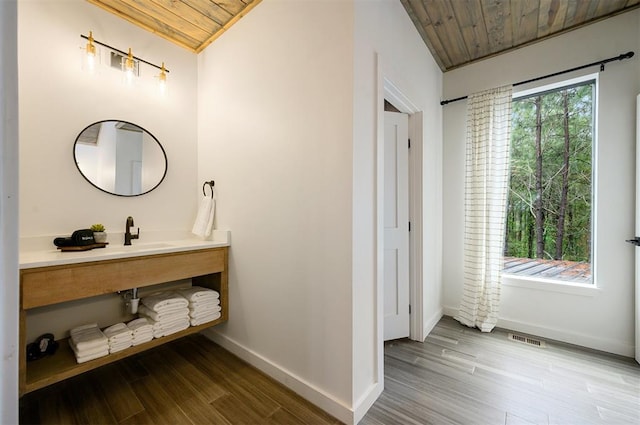 bathroom with hardwood / wood-style floors, plenty of natural light, and wooden ceiling