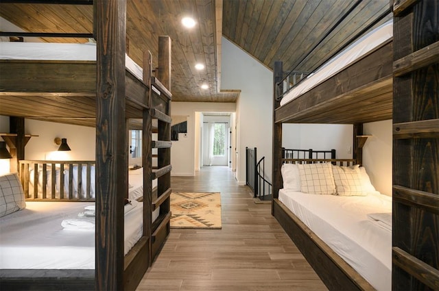 bedroom with high vaulted ceiling, wood ceiling, and wood-type flooring