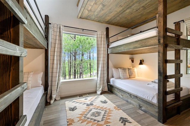 bedroom featuring light wood-type flooring and wood ceiling