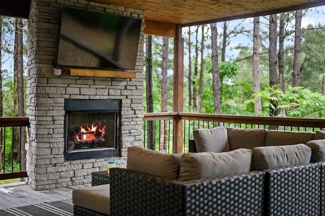 deck with an outdoor stone fireplace