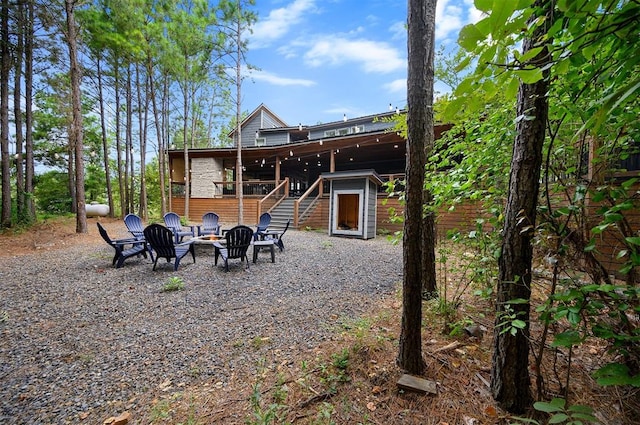 back of house featuring a fire pit and a wooden deck