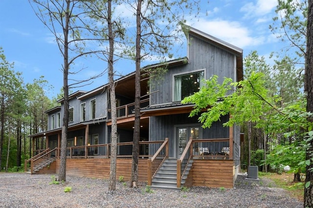 rear view of property featuring stairs and central AC unit