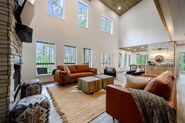 living area with a wealth of natural light, a fireplace, light wood-style flooring, and baseboards