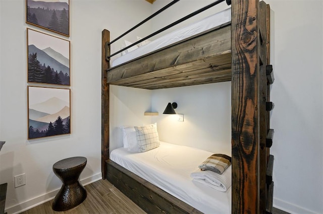 bedroom with baseboards and dark wood-style flooring