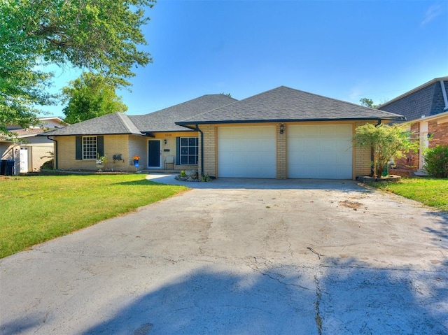 single story home featuring a front lawn and a garage