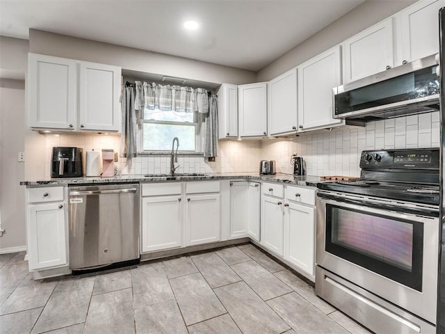 kitchen with light stone countertops, backsplash, stainless steel appliances, sink, and white cabinets