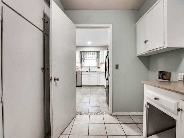 interior space featuring sink, light tile patterned floors, dishwasher, white cabinets, and fridge