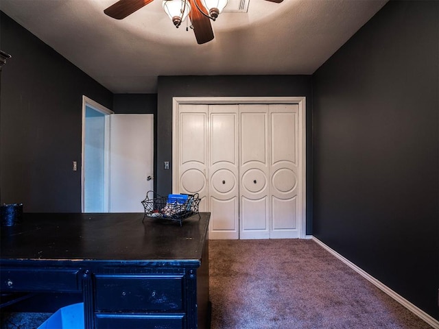 carpeted home office featuring ceiling fan