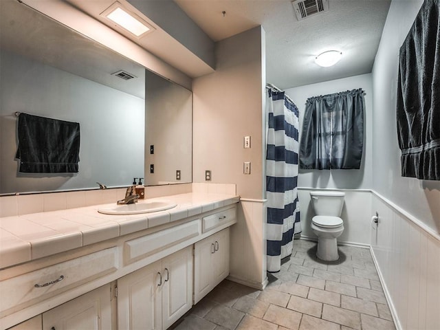 bathroom featuring vanity, toilet, and a textured ceiling