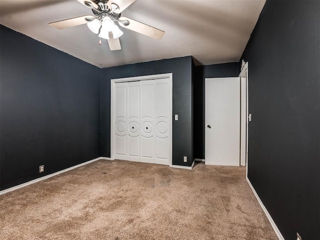 unfurnished bedroom featuring ceiling fan, a closet, and carpet floors