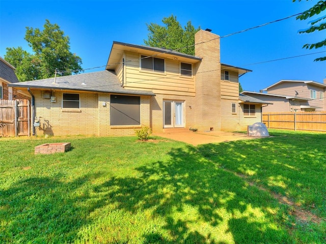 back of house with a lawn and a patio area