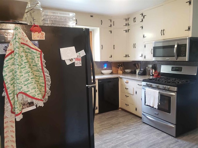 kitchen featuring black appliances, white cabinets, light wood-type flooring, and tasteful backsplash