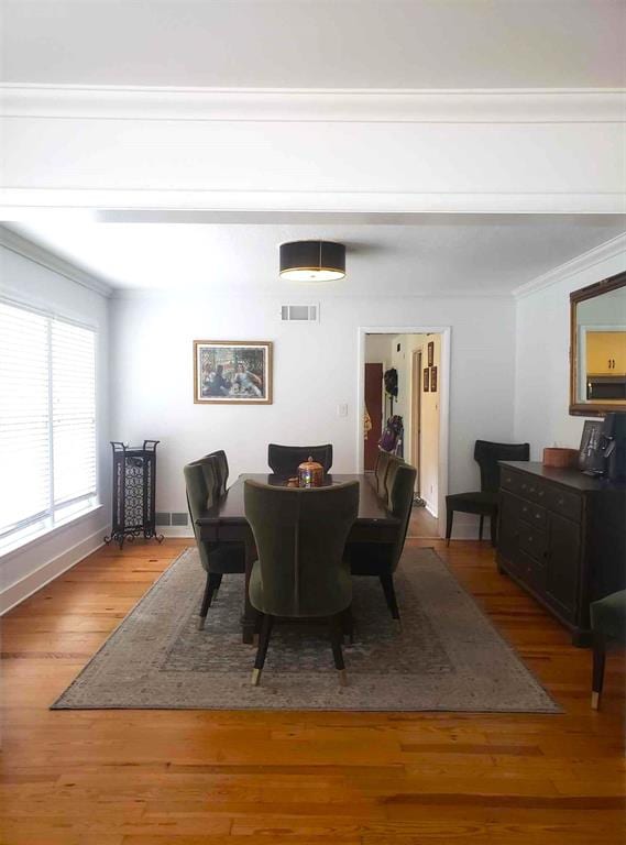 dining area featuring hardwood / wood-style floors and crown molding