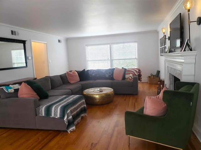 living room featuring a wealth of natural light, hardwood / wood-style floors, and ornamental molding