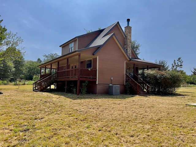 back of house featuring a lawn, covered porch, and central AC