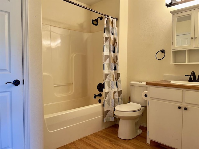 full bathroom featuring hardwood / wood-style flooring, vanity, toilet, and shower / tub combo