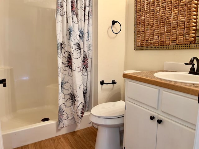 bathroom with hardwood / wood-style floors, vanity, curtained shower, and toilet