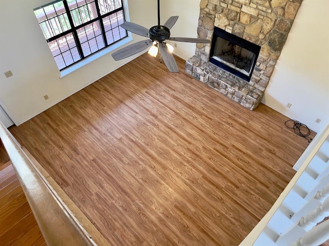 unfurnished living room featuring a fireplace, hardwood / wood-style flooring, and ceiling fan