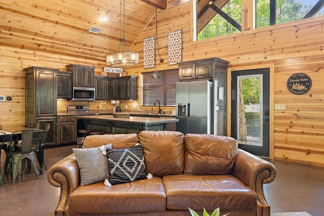 living room with sink, high vaulted ceiling, a wealth of natural light, and wood walls