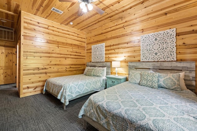 carpeted bedroom featuring ceiling fan, wooden ceiling, and wood walls