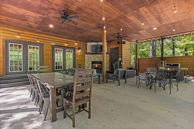 exterior space with ceiling fan, an outdoor stone fireplace, wooden ceiling, and french doors