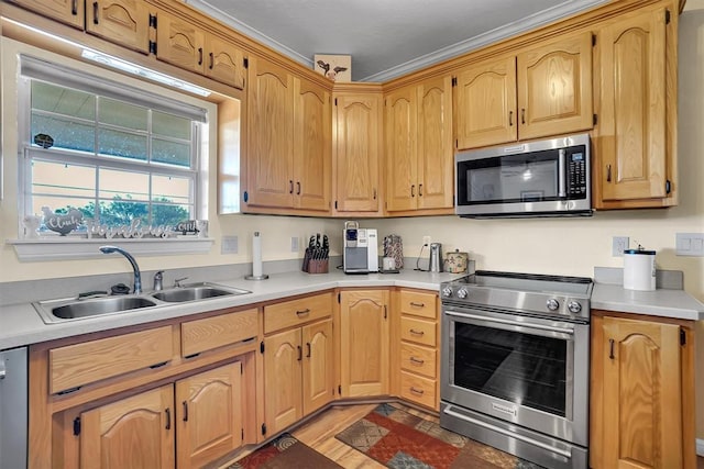 kitchen featuring hardwood / wood-style flooring, ornamental molding, sink, and appliances with stainless steel finishes