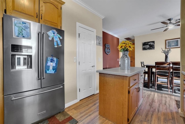 kitchen featuring ceiling fan, light hardwood / wood-style flooring, high quality fridge, a kitchen island, and ornamental molding