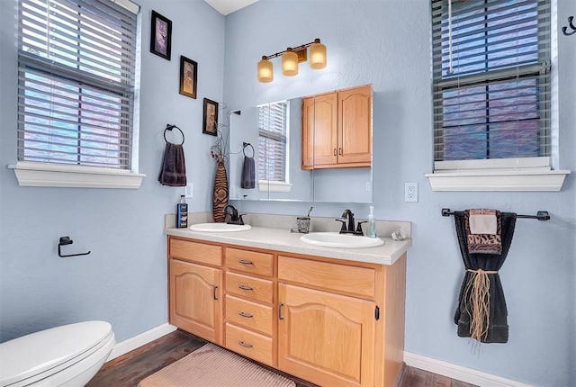 bathroom with hardwood / wood-style floors, vanity, and toilet