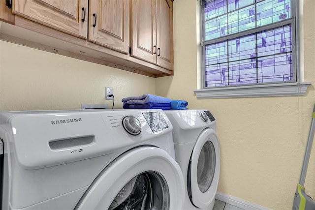 washroom with cabinets and washing machine and clothes dryer